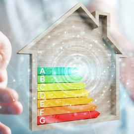 Energieeffizienz im Fokus: Ein Haus mit Bewertungsskala Zwei Hände die ein Energieeffizienzklasse mit einem Haus umrandet halten