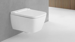 Eine moderne, wandmontierte Toilette in strahlendem Weiß, die elegant an einer grauen Wand angebracht ist.