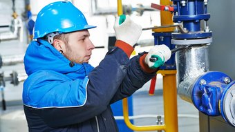 Facharbeiter bei der Wartung von Rohrleitungen in der Industrie Ein Mechaniker im Notdienst der eine Anlage repariert