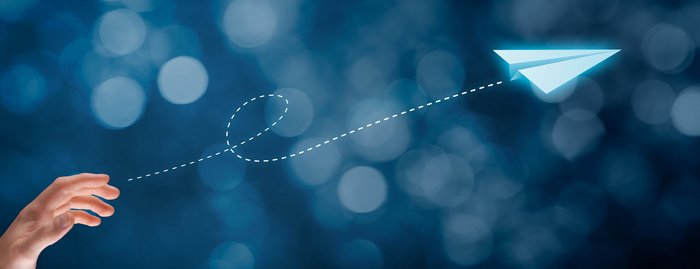 Ein Papierflieger und eine Hand