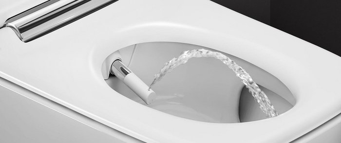 Moderne Toilette mit innovativer Wasserfunktion Ein modernes Bidet mit einem Wasserstrahl, der aus der Düse in die Toilettenschüssel spritzt, auf einem weißen Hintergrund.