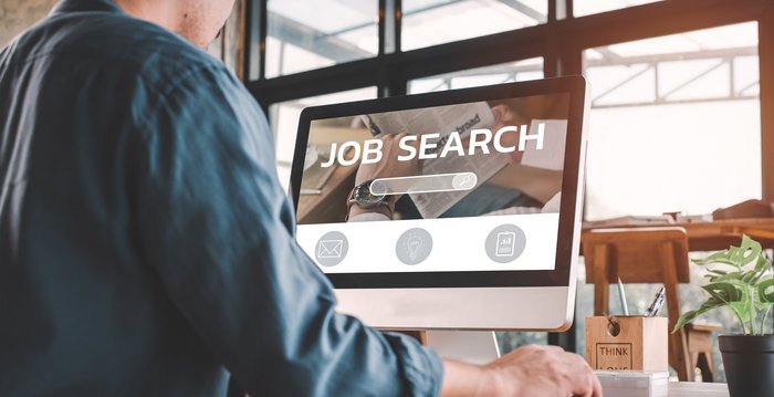 Mann sucht nach neuen Jobmöglichkeiten am Computer Ein Mann der an einem Pc nach Stellenangeboten sucht