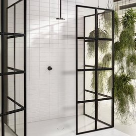 Eine moderne Dusche mit schwarzen Glastüren und weißen Fliesen, umgeben von hängenden Pflanzen für ein frisches Ambiente.