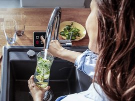 Erfrischendes Getränk mit Zitrone und Minze zubereiten Küchenspühle mit einem Display, ein Smarter Wasserhahn